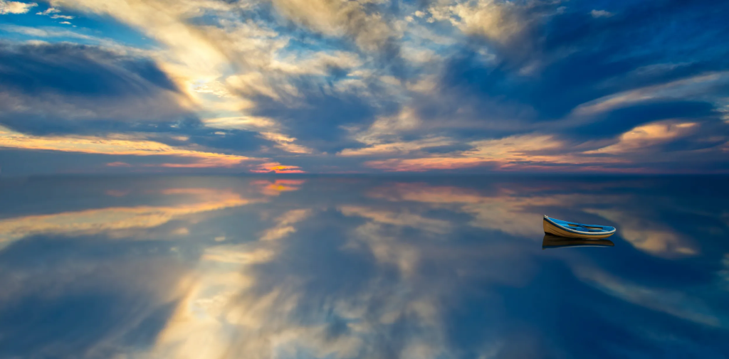 A small boat floats on a blue sea.
